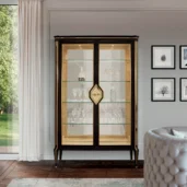 Luxury Italian glass cabinet with gold accents, showcasing elegant crystalware in a modern living room setting.