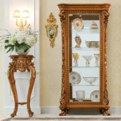 Luxurious handmade wooden cabinet and table with intricate detailing, displaying fine glassware in an elegant setting.