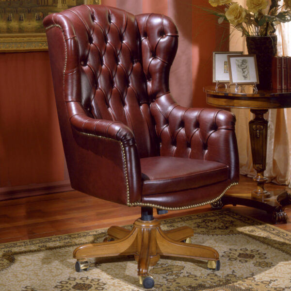 Poltrona direzionale in pelle bordeaux con schienale trapuntato, borchie in ottone e base in legno con ruote