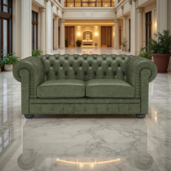 A green leather Chesterfield sofa positioned in the center of an elegant room with marble flooring, high ceilings, classical columns, and ornamental plants.