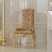 Elegant handcrafted Italian wooden chair with floral upholstery in luxurious villa interior design setting.