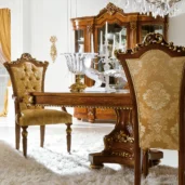 Luxurious Italian furniture set with ornate wooden dining table and upholstered chairs in elegant room setting.