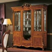 Luxurious Italian wooden display cabinet with ornate design, showcasing elegant glassware and fine craftsmanship.