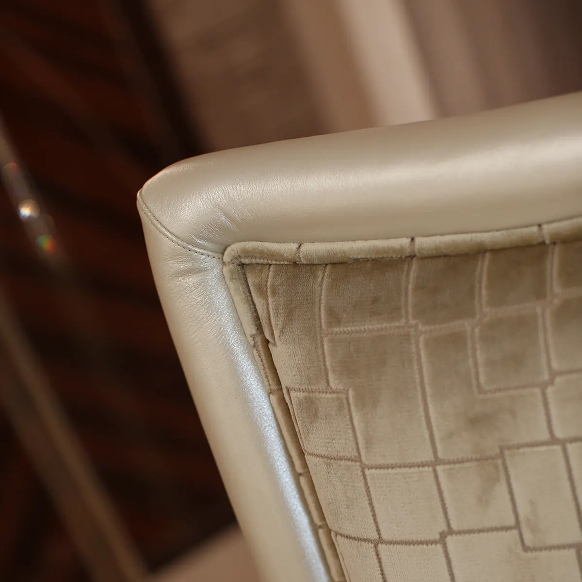 Close-up of luxury handcrafted fabric and leather chair design by Italian furniture artisans.