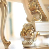 Luxury Italian furniture leg with ornate gold accents, showcasing elegant design and craftsmanship.