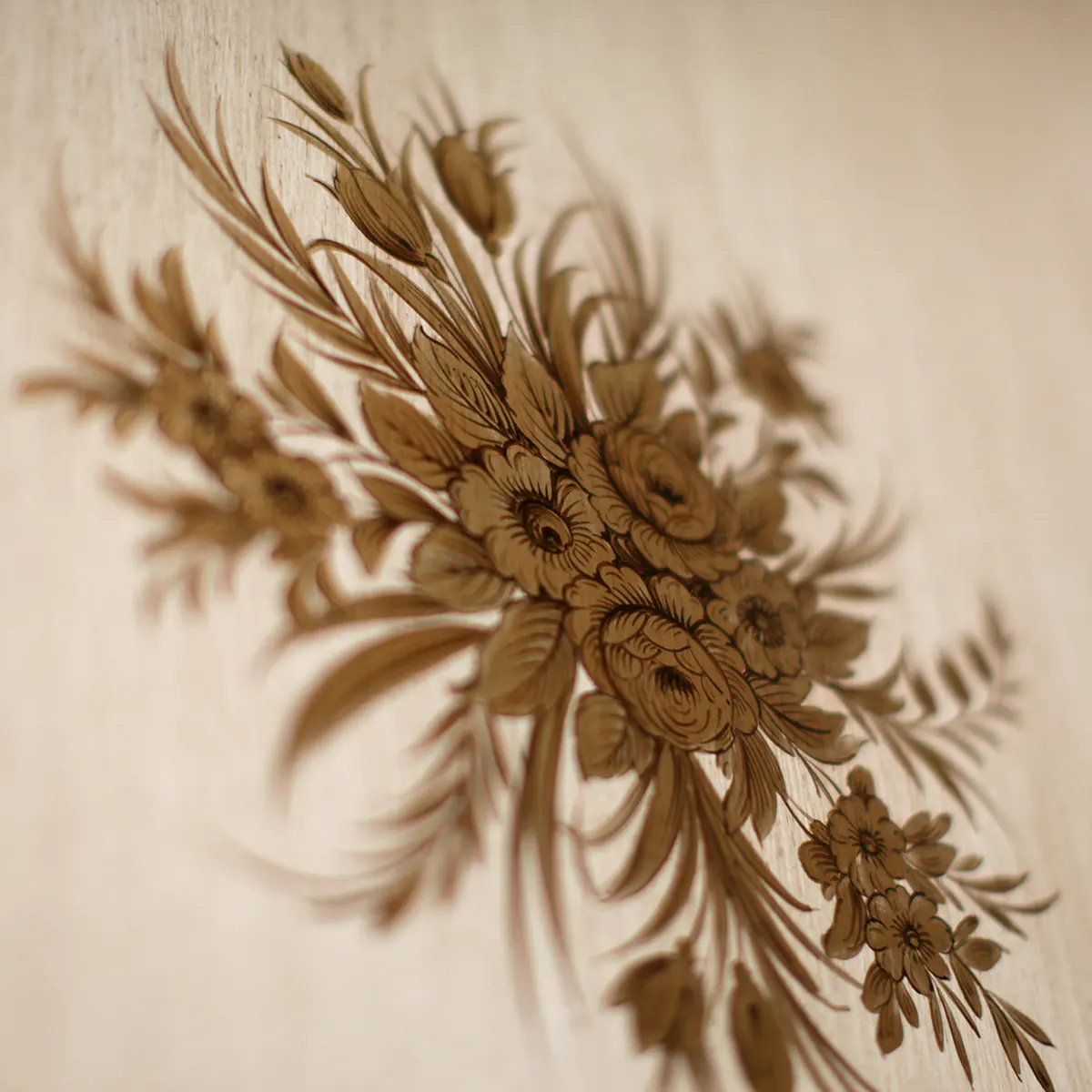 Intricate floral wood carving detail on luxury Italian furniture design, showcasing fine craftsmanship and elegance.