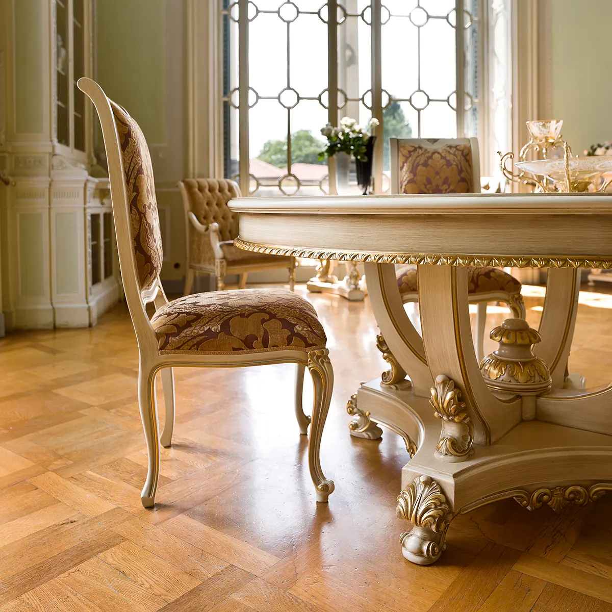 Luxurious Italian dining room furniture with ornate table and chairs in elegant, classic design by high-end manufacturer.