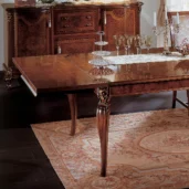 Luxurious handmade Italian wood dining table with intricate detailing and elegant decor in a classic setting.