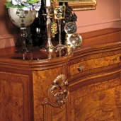 Handcrafted wooden furniture with elegant decor, featuring a polished finish and ornate carvings, Italian design.