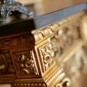 Close-up of intricate gold wood carving on luxury Italian handmade furniture. Elegant design for villas and palaces.