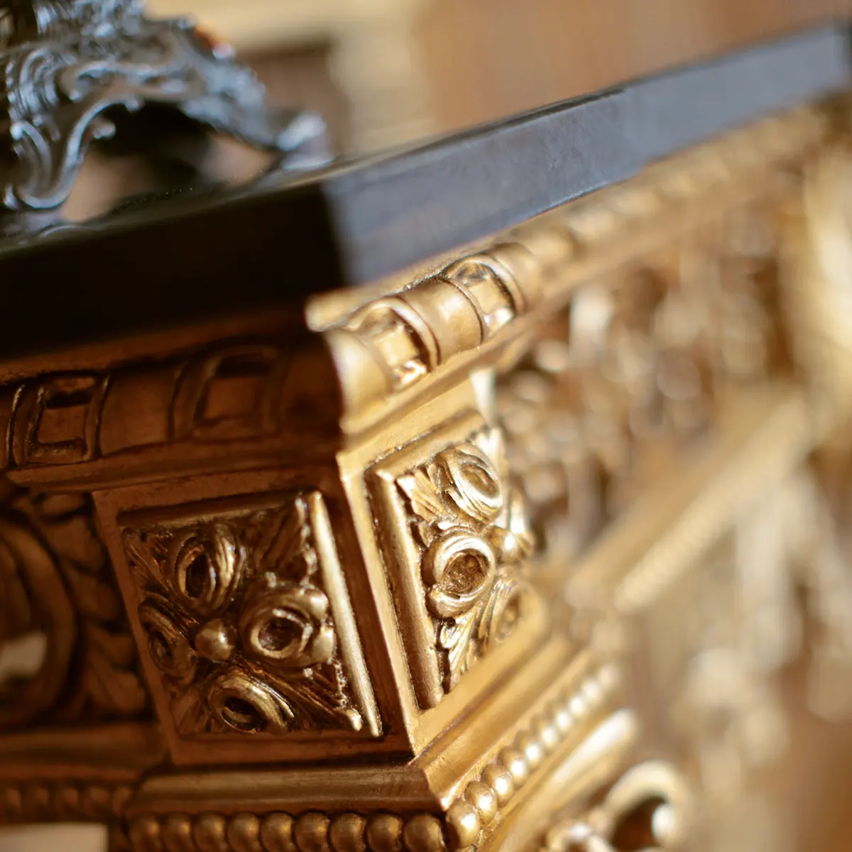 Close-up of intricate gold wood carving on luxury Italian handmade furniture. Elegant design for villas and palaces.