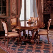 Elegant handmade wooden dining table and chairs, set in a luxurious villa interior with ornate drapery and carpet.