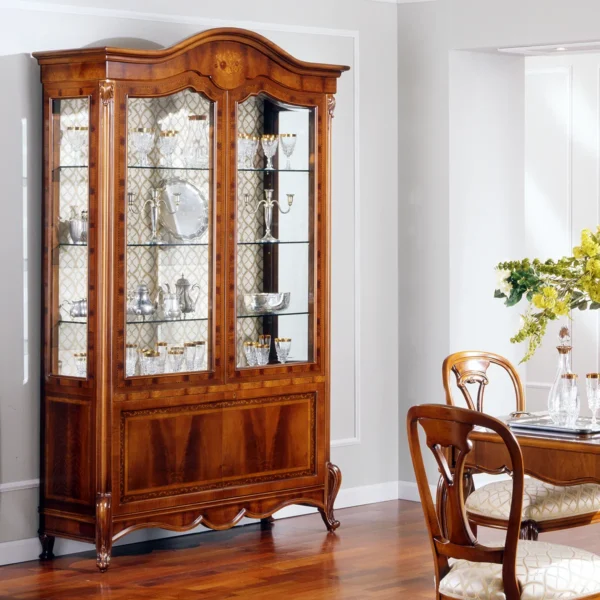 Elegant handcrafted wooden display cabinet showcasing fine glassware in a sophisticated Italian villa dining room.