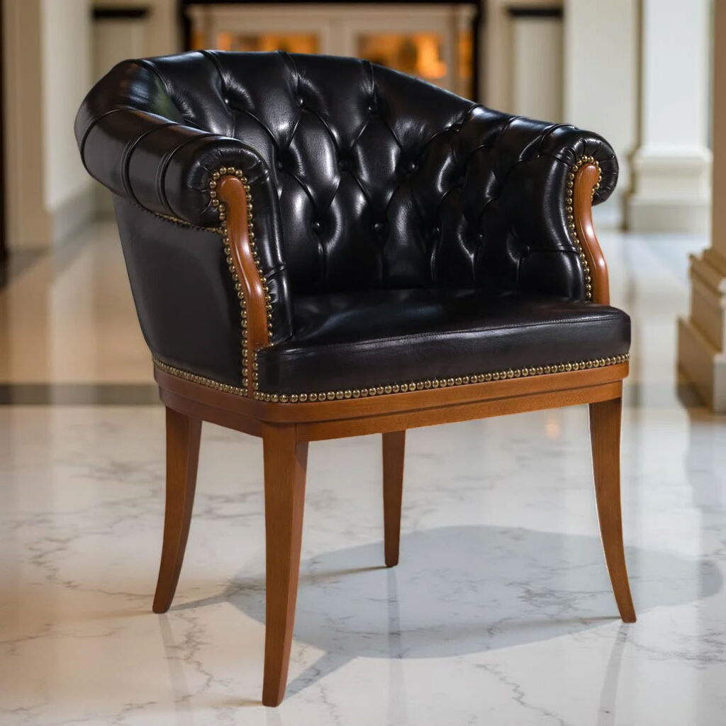 Poltrona in pelle nera con schienale trapuntato, borchie in ottone e gambe in legno su pavimento in marmo