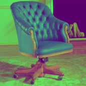 Blue leather office armchair with tufted backrest, wooden accents, brass nailhead trim, and five-leg base with casters