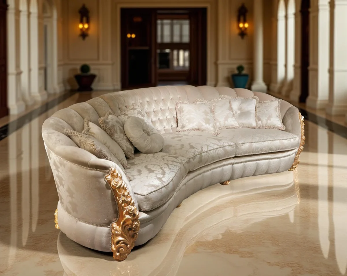 Divano curvo di lusso con dettagli dorati, tessuto chiaro decorato e cuscini eleganti in un atrio con colonne e pavimento in marmo.