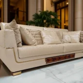 Divano di lusso in pelle con dettagli in legno e inserti dorati, stile moderno con influenze classiche.