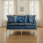 Divanetto classico in velluto blu scuro con cornice dorata, cuscini decorati e motivi floreali