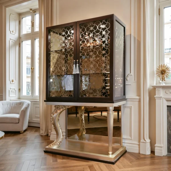 Luxus‑Vitrine mit Glastüren und goldfarbenem Ziergitter, auf Konsolenbasis mit geschnitztem Volutenbein in Gold und kannelierter Säule.
