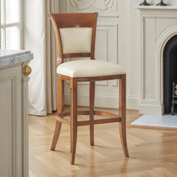 Counter‑height wooden barstool with flared legs and footrest, light upholstered seat and padded back panel – Marzorati.
