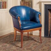 Marzorati executive armchair in blue leather, barrel-back design with rolled arms and solid wood legs for classic offices.