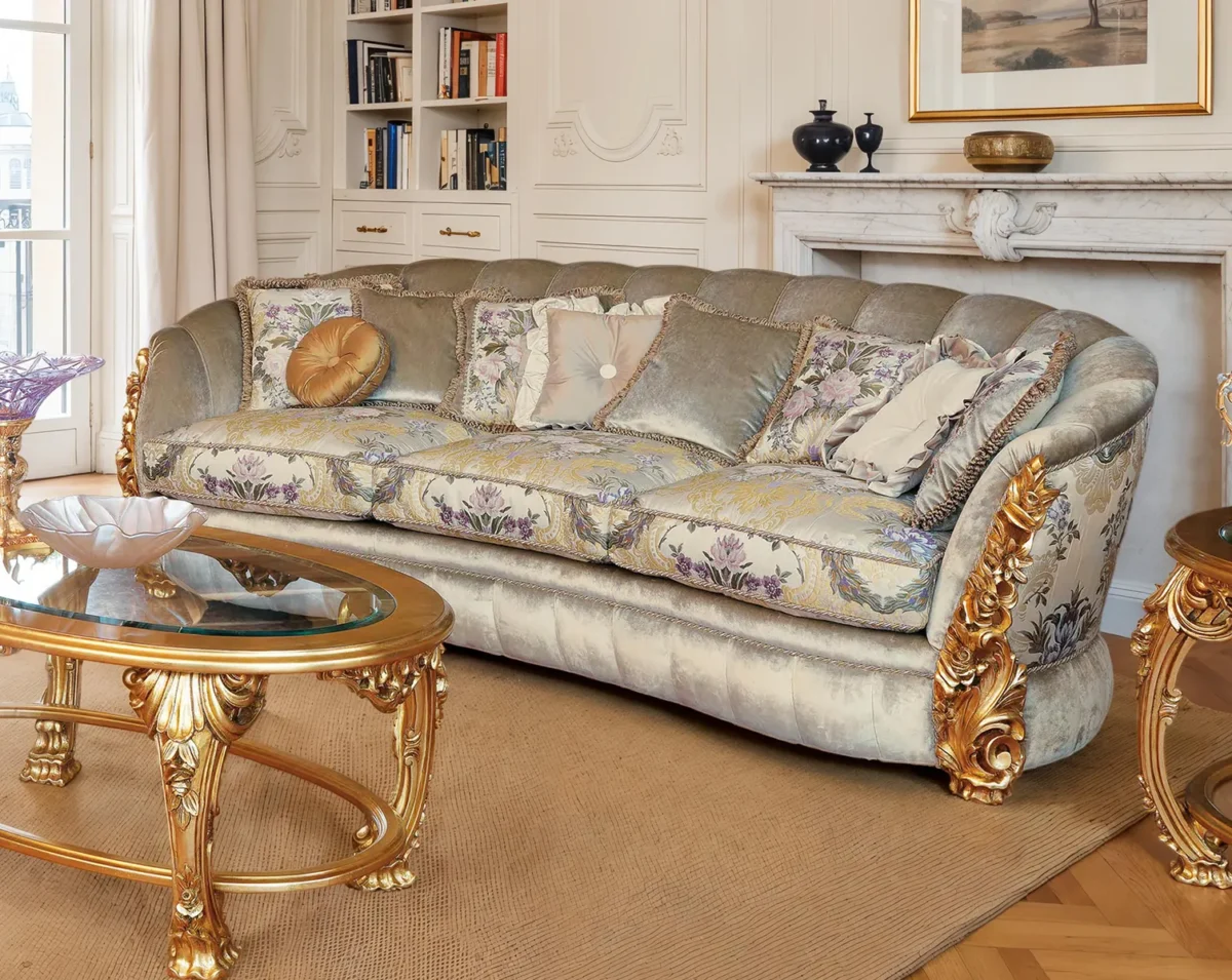 Divano classico con velluto chiaro, cuscini floreali decorativi e intagli dorati in un salotto raffinato