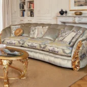 Divano classico con velluto chiaro, cuscini floreali decorativi e intagli dorati in un salotto raffinato