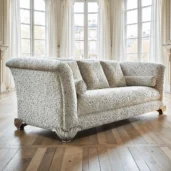 Divano classico con rivestimento floreale color crema e piedini intagliati a forma di conchiglia in un elegante ambiente luminoso