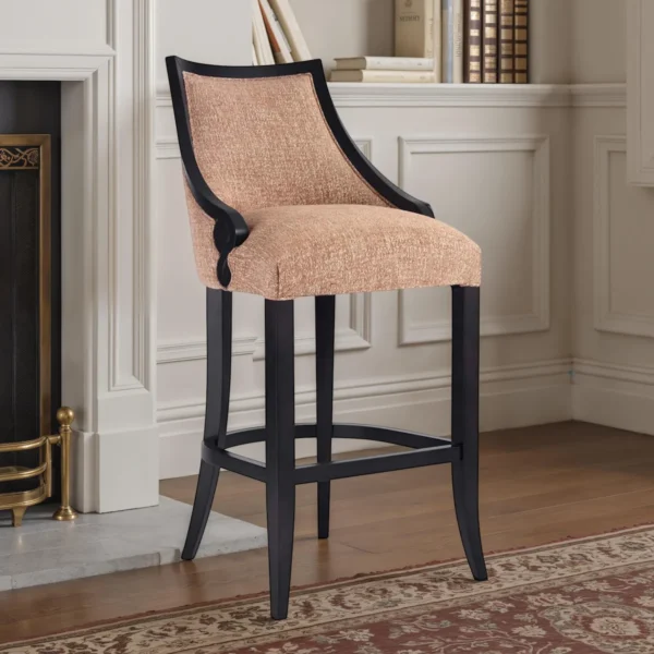 Luxury upholstered bar stool in beige fabric with curved back and black wooden frame with footrest.