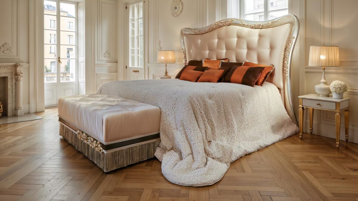 King-size pearl velvet bed with scalloped tufted headboard and carved frame in silver and gold leaf, bronze accent pillows.