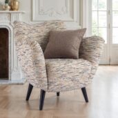 Poltrona moderna compatta con rivestimento in tessuto geometrico grigio, gambe in legno e cuscino coordinato