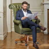 Green leather executive armchair with solid wood base handcrafted by Marzorati