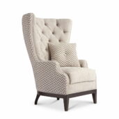 Designer armchair with tufted high backrest, beige fabric upholstery, dark wooden legs and matching cushion
