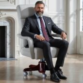 Luxurious white leather executive swivel armchair with contemporary design, placed in a bright lounge with marble fireplace and windows, perfect for high-end home office furniture and elegant comfort.