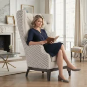 Elegante poltrona wingback di lusso in tessuto beige con motivo chevron, design capitonné, in un ambiente soggiorno sofisticato.