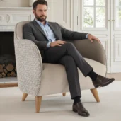 Poltrona accent di lusso moderna in beige con motivo geometrico textured su braccioli e schienale, design arrotondato, in un elegante soggiorno.
