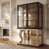 Luxury eclectic bar cabinet display with decorative glass doors, internal lighting and sculptural two-tone base for the living room.