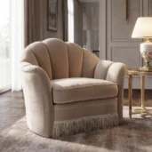 Luxury living room armchair with enveloping shell backrest, fringe skirt and soft neutral upholstery in fine Italian fabrics.
