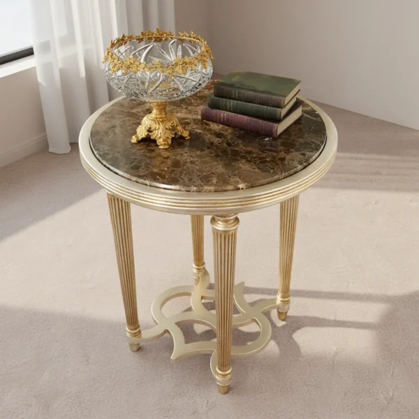 Studio shot of a luxury round side table with brown marble top and fluted gold legs, featuring a crystal bowl and antique books prop