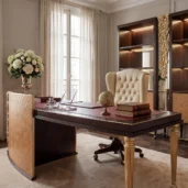 High-end executive office desk featuring a curved geometric modesty panel, gold fluted legs, and a beige tufted leather swivel chair