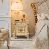 Nightstand, hand-carved in baroque style with gold details, beside the collection's bed