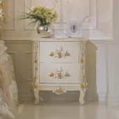 Eleonor nightstand in hand-carved wood with floral details and gold accents.