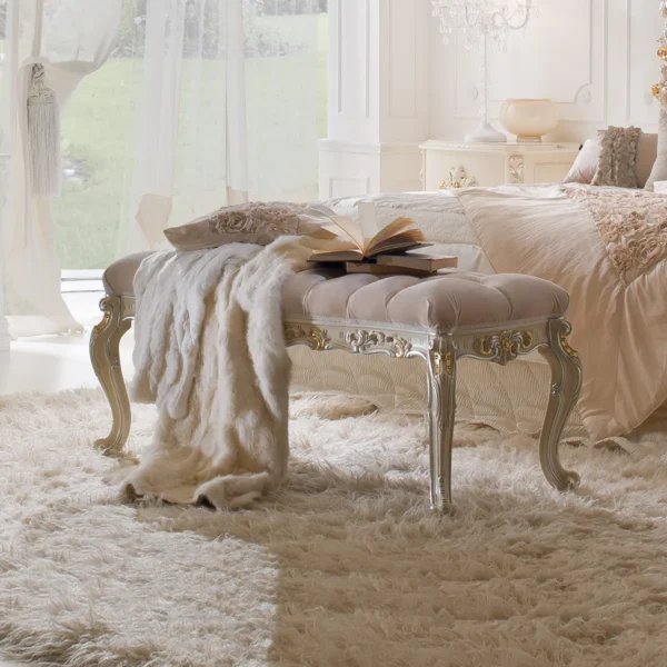 Eleonor hand-carved wood bench styled in an elegant Italian bedroom setting.