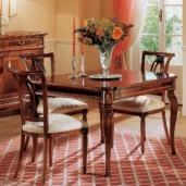 Granducato table with hand-carved chairs, styled in an Italian villa with floral centerpiece.