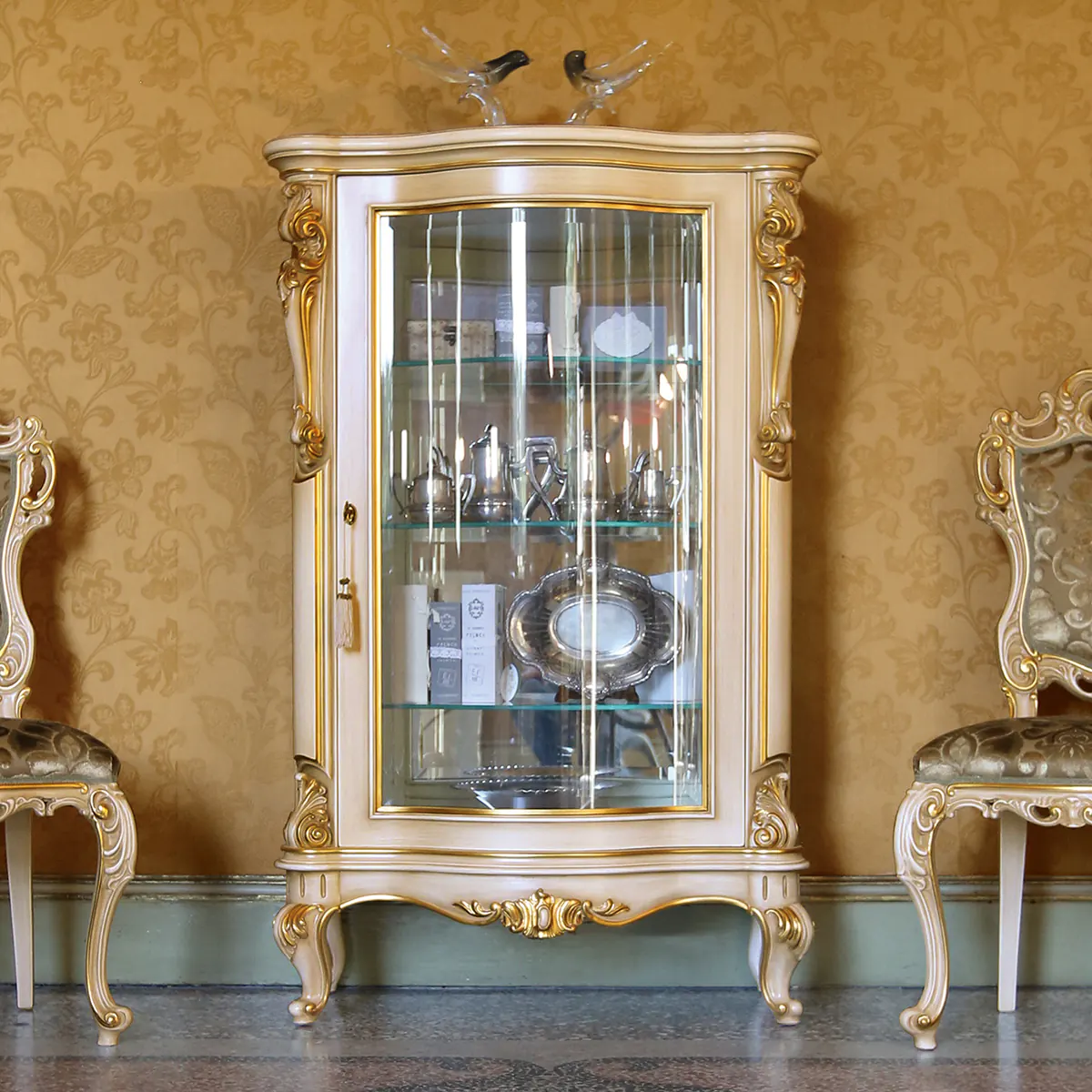LOUVRE curio cabinet thumbnail EN Louvre 1-door curio cabinet in carved wood with gold details, luxury Italian craftsmanship.