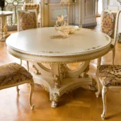Prestige round table in carved wood with gold details.