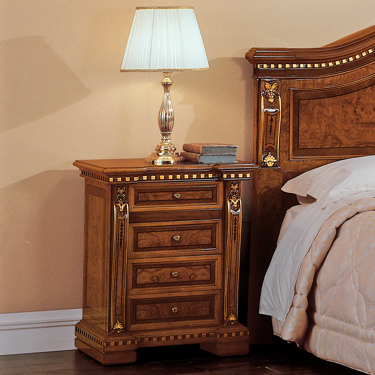REGINA nightstand Elegant handcrafted Regina wooden nightstand with ornate details next to bed, topped with silver lamp and books.