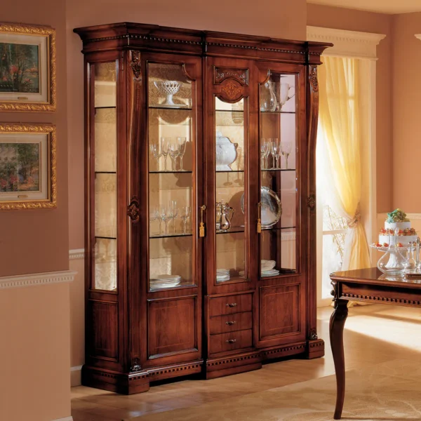 Elegant handcrafted Regina wood display cabinet with glass doors showcasing fine dining sets in a luxurious interior.