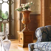 Senator flower stand in carved wood with floral arrangement, in a luxury setting.