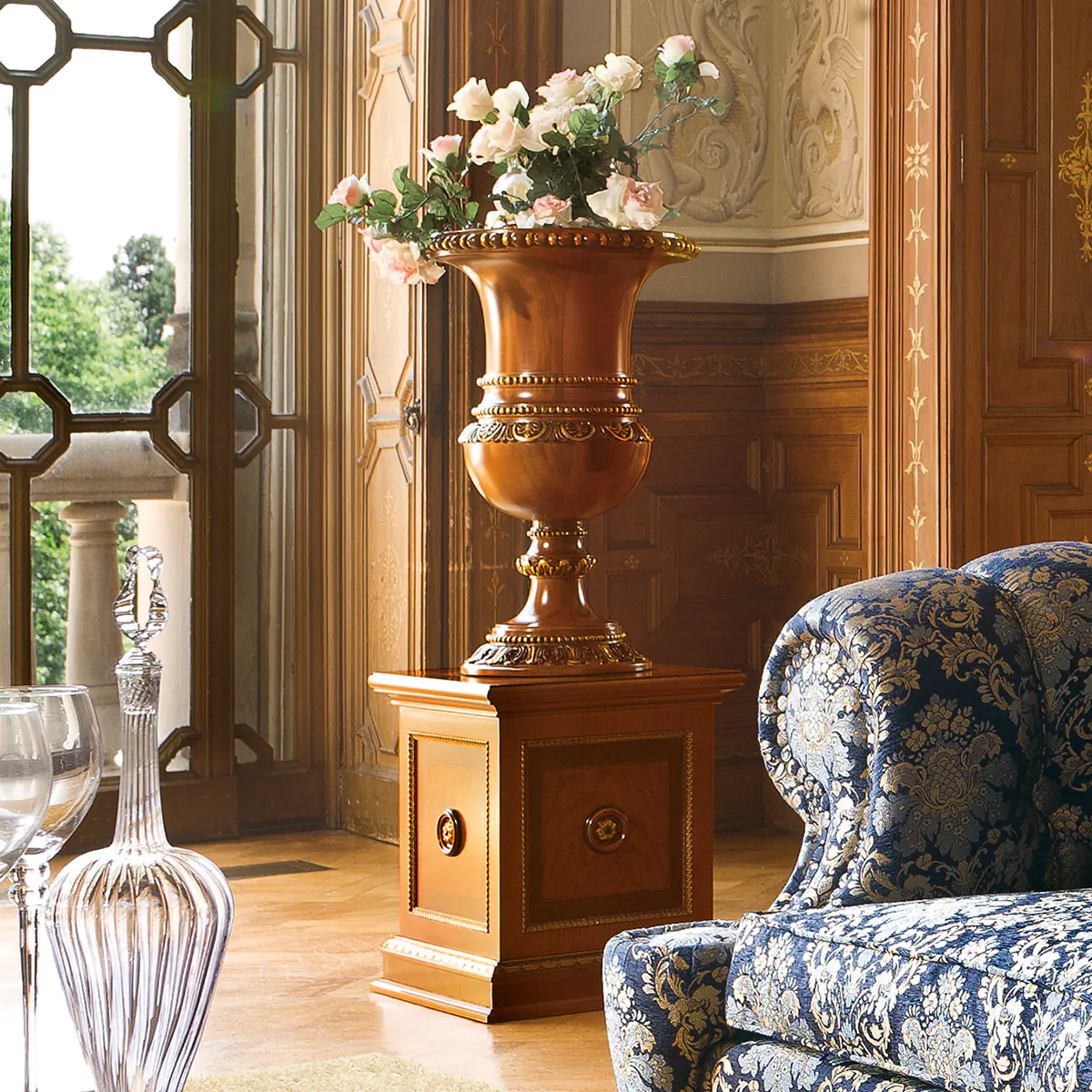 SENATOR flower stand Senator flower stand in carved wood with floral arrangement, in a luxury setting.